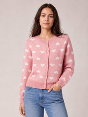 Model wearing a pink heart pattern button-front cardigan with long sleeves, ribbed neckline, cuffs and hem, and a fitted silhouette.