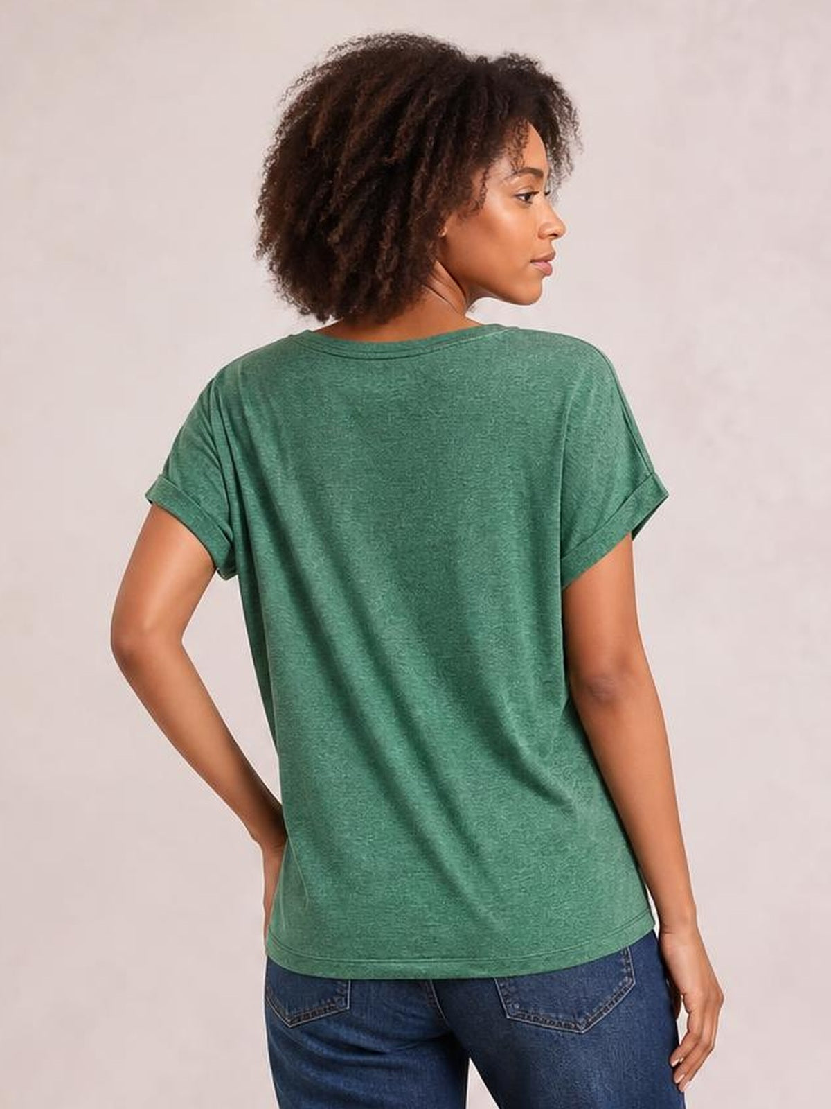 A model poses from the back wearing a green heathered short-sleeve T-shirt with rolled cuffs and a relaxed, straight silhouette.