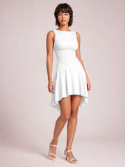 Model poses in a white sleeveless mini dress with a round neck, fitted waist, softly flared silhouette, and flowing high-low hem.