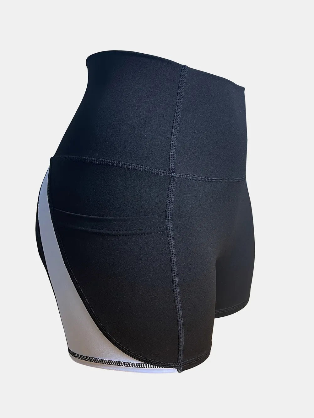 Black high-waist active shorts with a fitted silhouette, wide waistband, visible stitching, and contrasting white side panels.