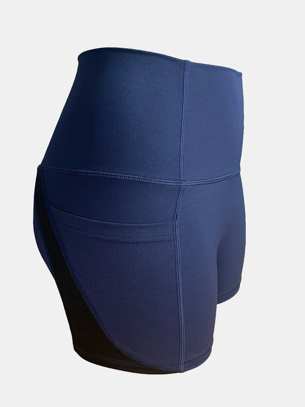 Navy high waist active shorts shown in a rear three-quarter view, featuring a fitted silhouette, wide waistband, curved panel seams, and moderate stretch.