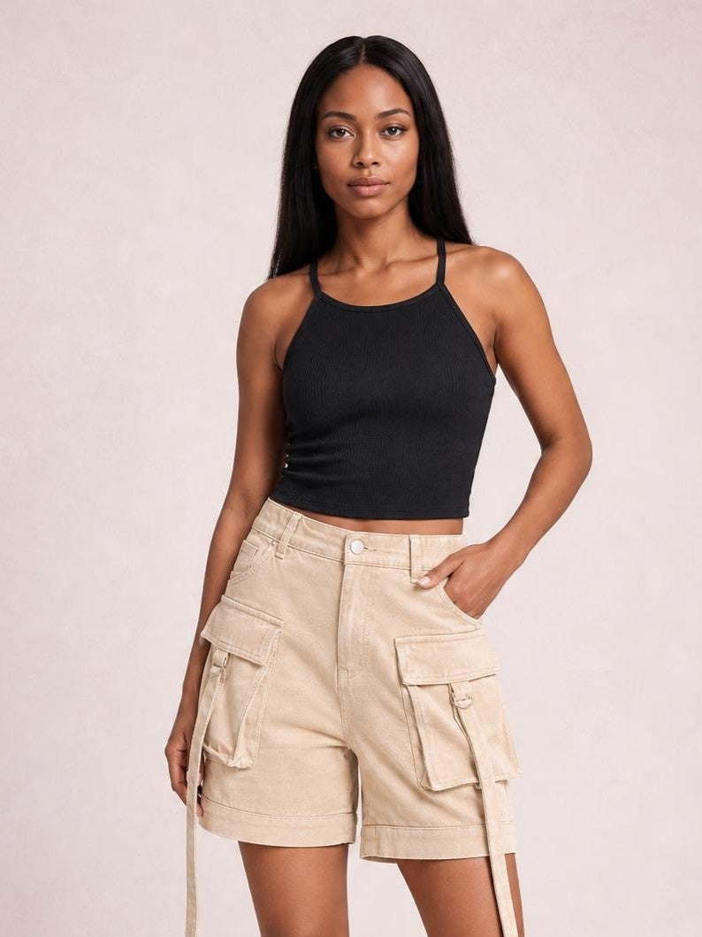 A woman modeling a black ribbed halter crop top and beige cargo shorts against a light beige studio background.