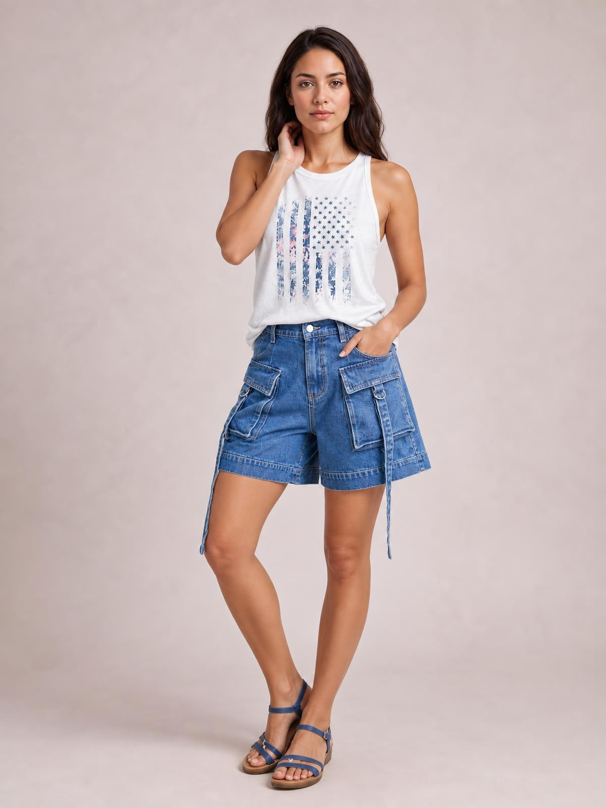 Model poses with one hand in her pocket, wearing blue high-waist denim cargo shorts with a relaxed silhouette, flap pockets, and stitched panel details.