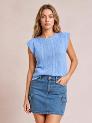 A model stands with one hand in a pocket, wearing a high-waist blue denim skirt with a straight mini silhouette, front closure, and cargo-style patch pockets.