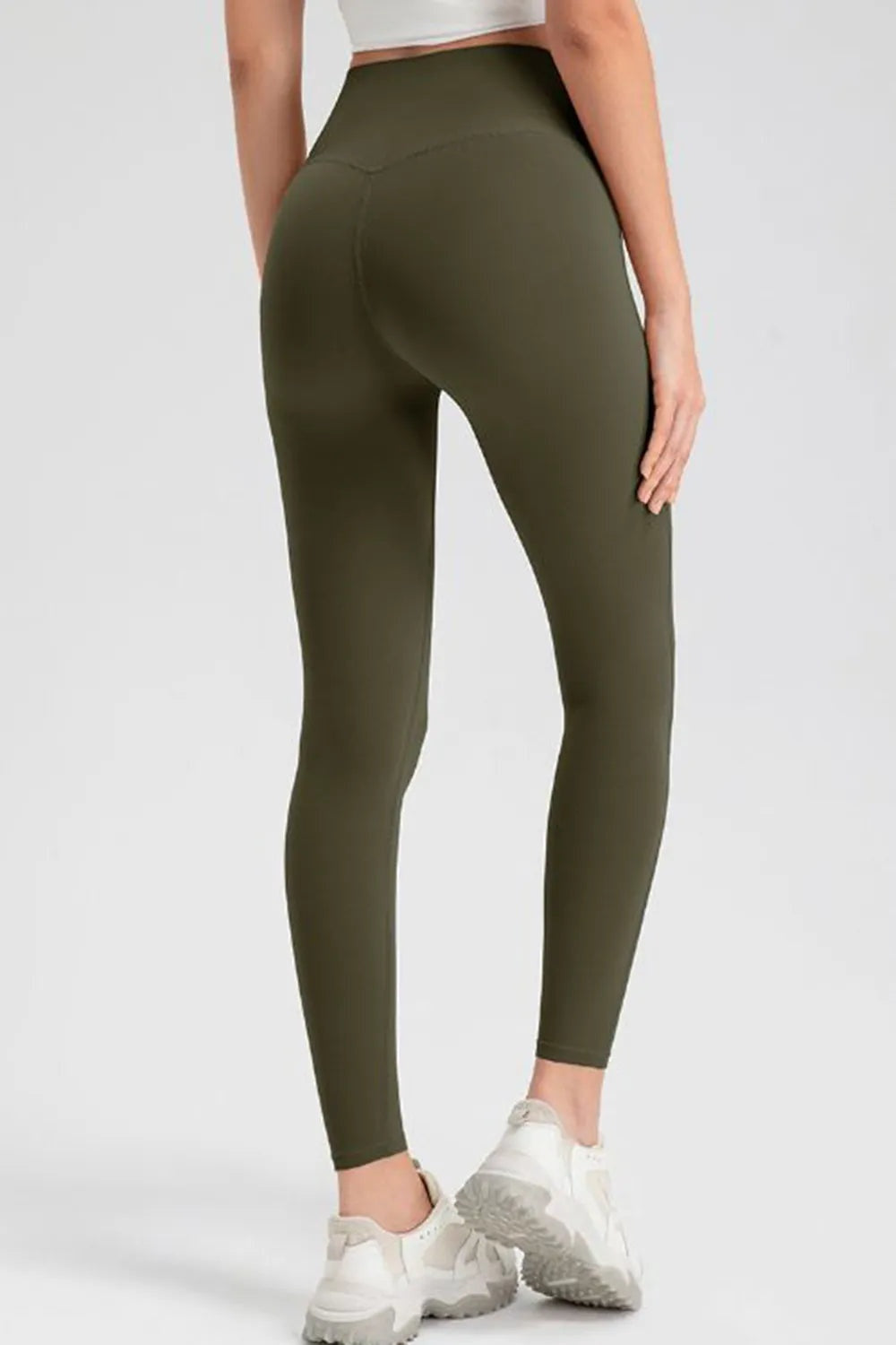 Model shown from behind wearing olive green high-waist skinny active pants with a smooth, fitted ankle-length silhouette and stretch construction.