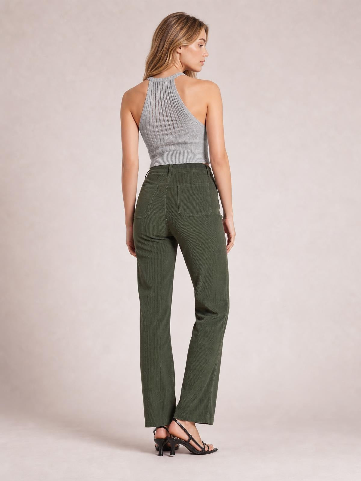 A model stands in a rear three-quarter pose wearing olive-green high-waisted corduroy pants with a straight-leg silhouette, belt loops, and square back pockets.