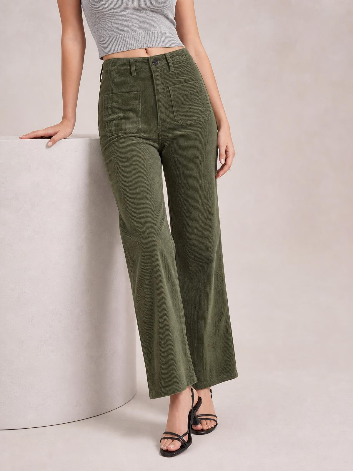 Model wears olive-green high-waist corduroy pants with square front pockets, belt loops, button closure, and a relaxed straight-leg silhouette.