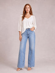 Model wearing light-wash high-waisted straight-leg jeans with front and side pockets, a button fly, and full-length structured legs.