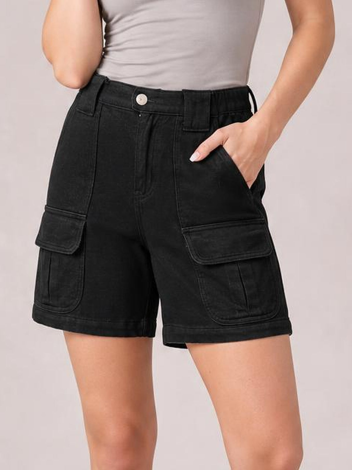 Model wears black high-waist washed denim shorts with a structured straight-leg silhouette, belt loops, button closure, and large utility pockets.