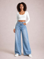 Model wearing light blue high-waist wide-leg jeans with a structured waistband, front pockets, button closure, and full-length flowing silhouette.