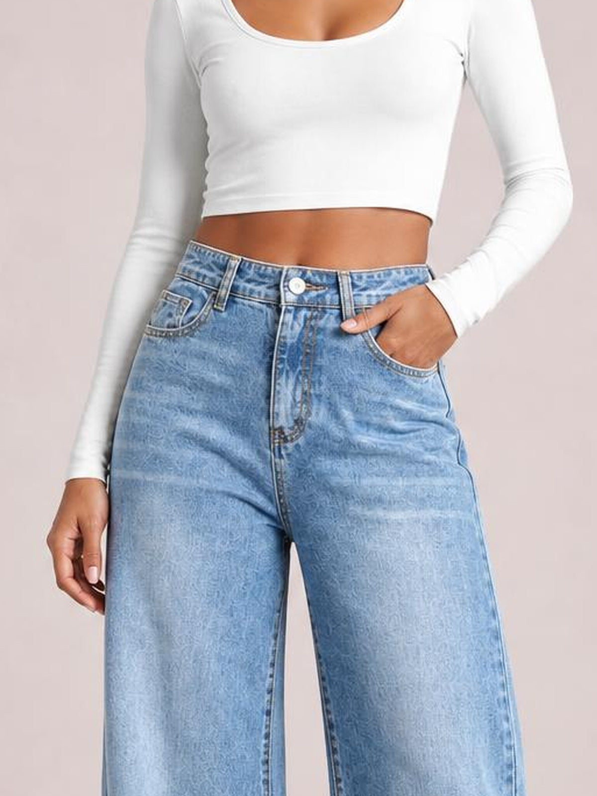 Model wears light blue high-waist wide-leg jeans with belt loops, front pockets, a button fly, and a relaxed silhouette.