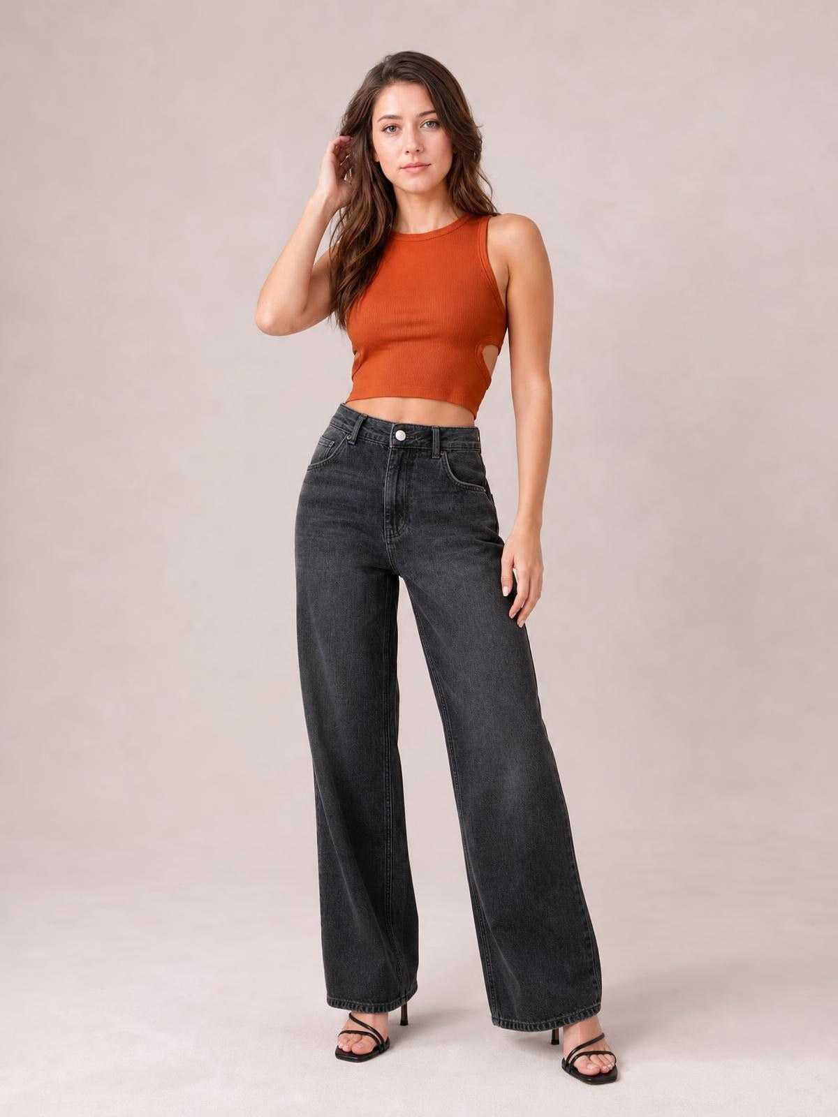 A model poses in dark gray high waist wide leg jeans with a button fly, belt loops, front pockets, and a full-length relaxed silhouette.