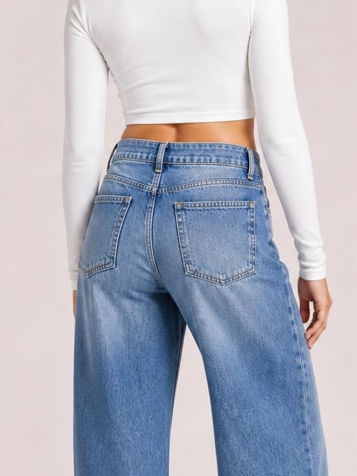 Model shown from the back wearing light blue high-waist wide-leg jeans with belt loops, buttoned waistband, contrast stitching, and back patch pockets.