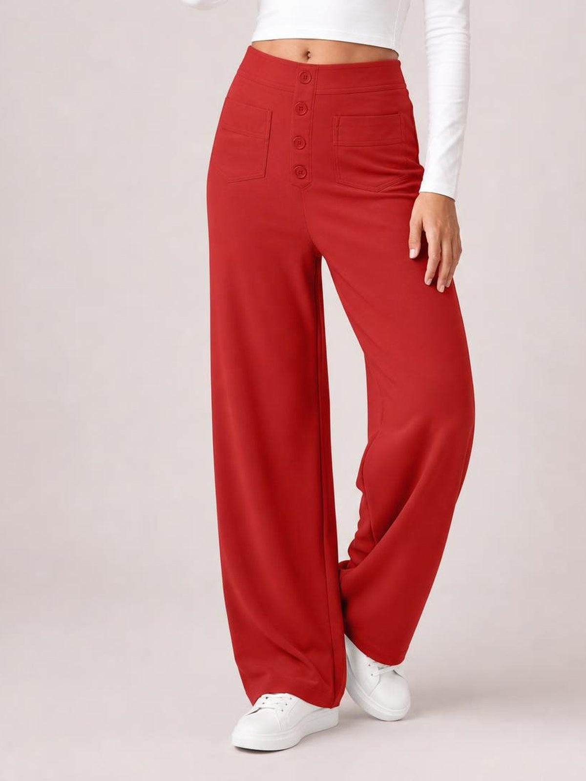 Model wearing red high waist wide leg pants with front patch pockets, a button fly, and relaxed full-length legs, posed with one leg crossed.
