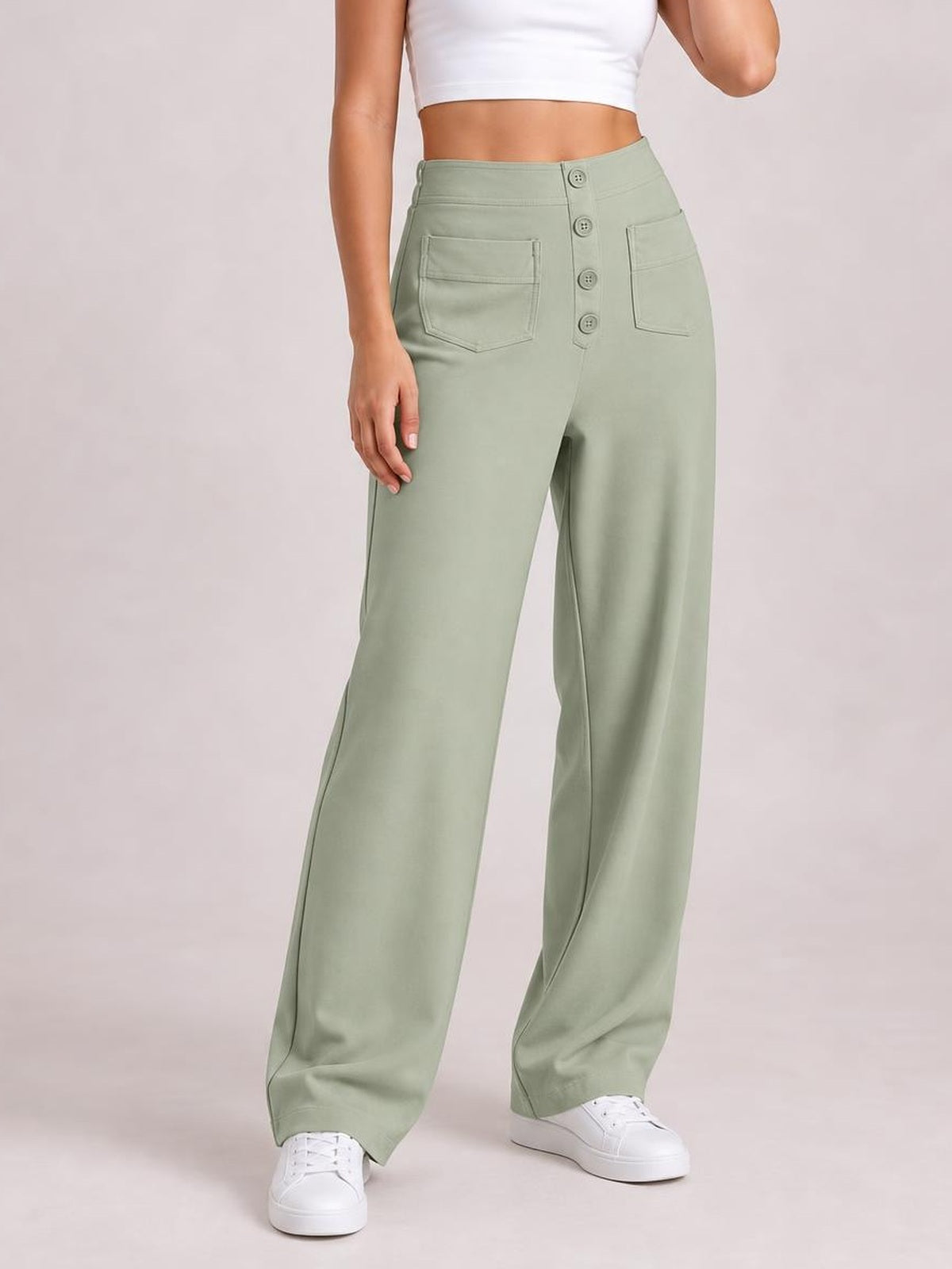 Model wearing sage green high waist wide leg pants with front patch pockets and a button fly, shown in a relaxed standing pose.