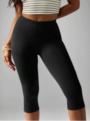 Model poses in black high-waisted active capri leggings with a smooth, fitted silhouette and clean stitched waistband and hems.