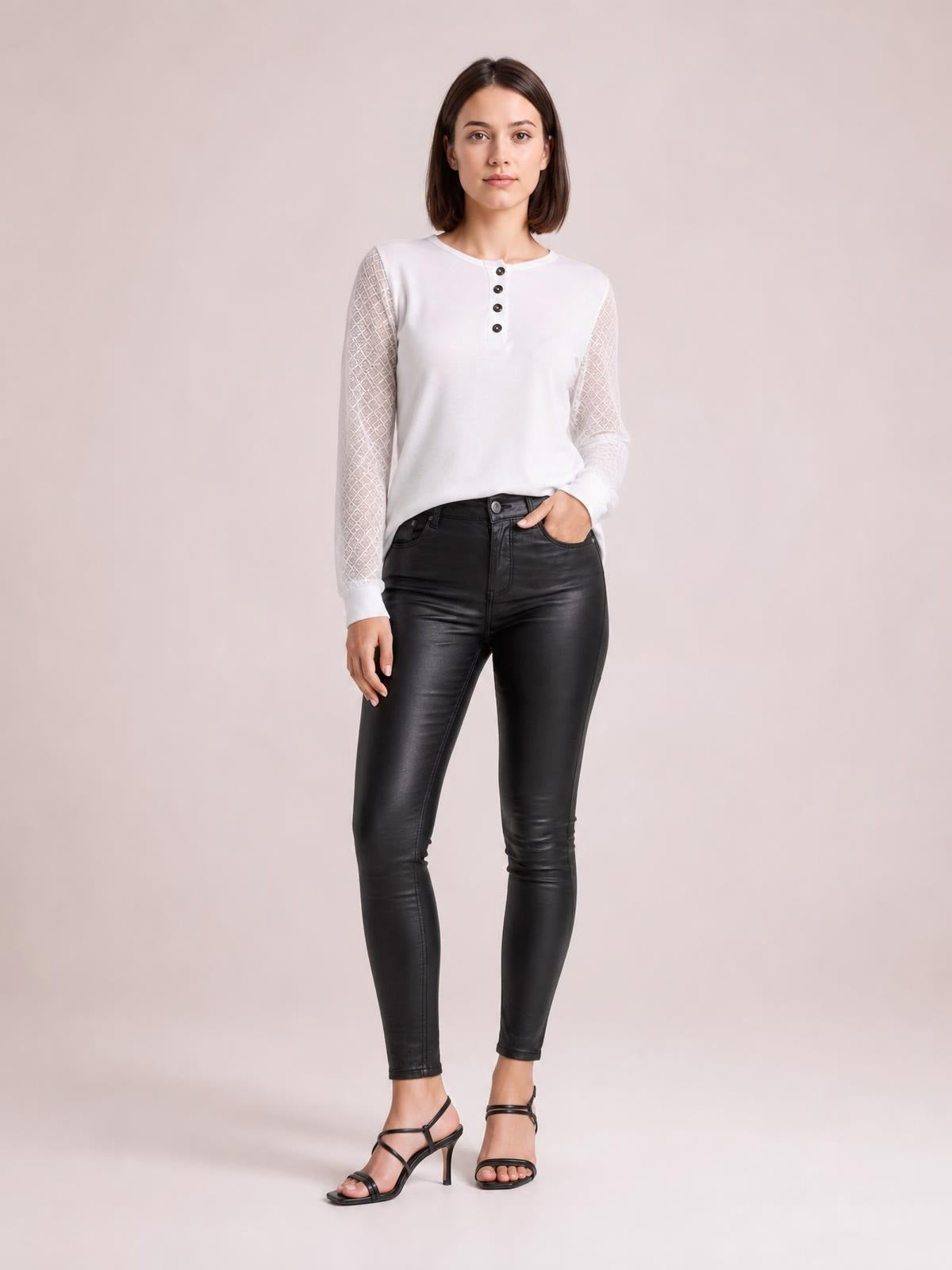 Model standing in black high-waisted faux leather skinny pants with a fitted silhouette, front button closure, belt loops, and visible pockets.