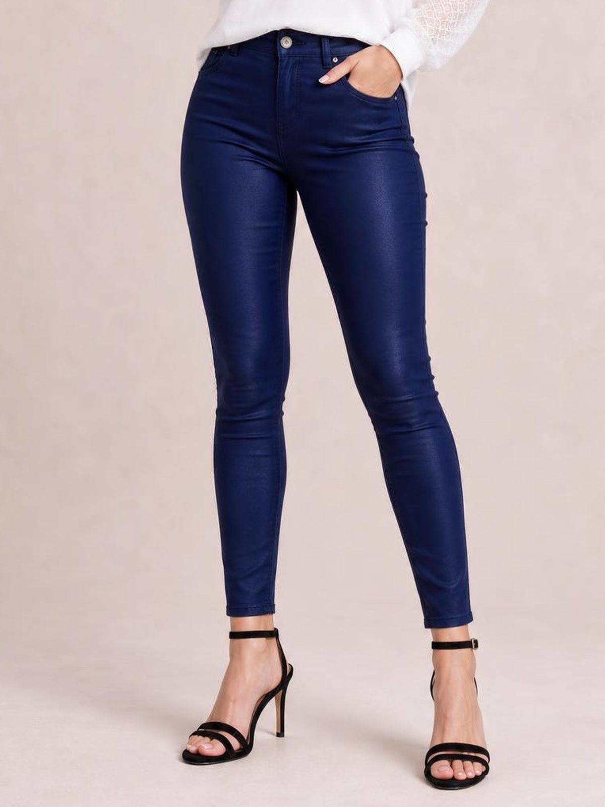 Model wears dark navy high-waisted faux leather skinny pants with front pockets, button closure, belt loops, and a close-fitting ankle-length silhouette.