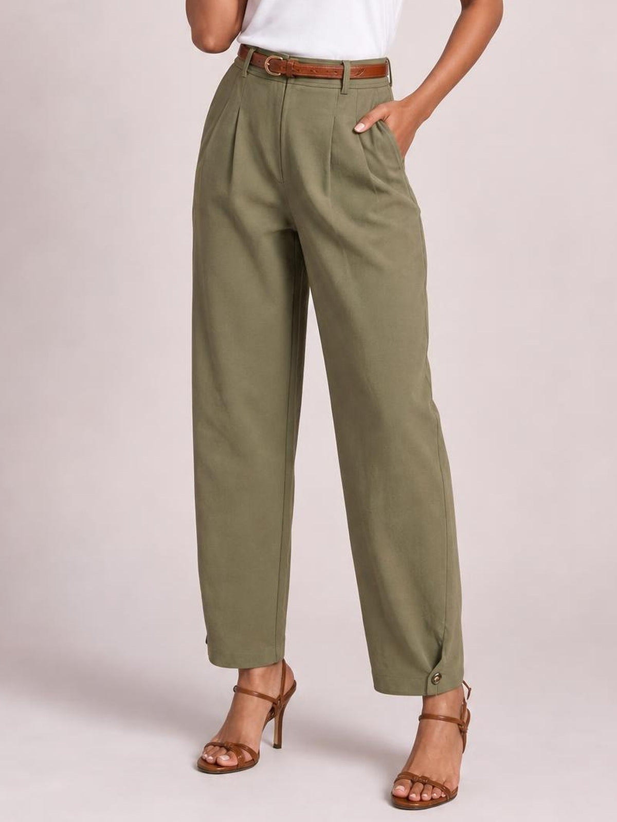 A model wears olive green high-waisted pleated pants with a relaxed straight-leg silhouette, belt loops, side pockets, and buttoned ankle cuffs.