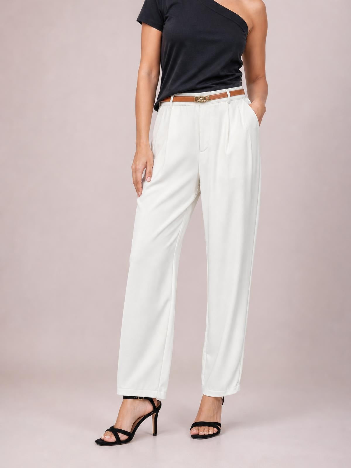 Model stands in white high-waisted pleated wide-leg pants, showing their relaxed silhouette, front pleats, straight hems, and side pockets.