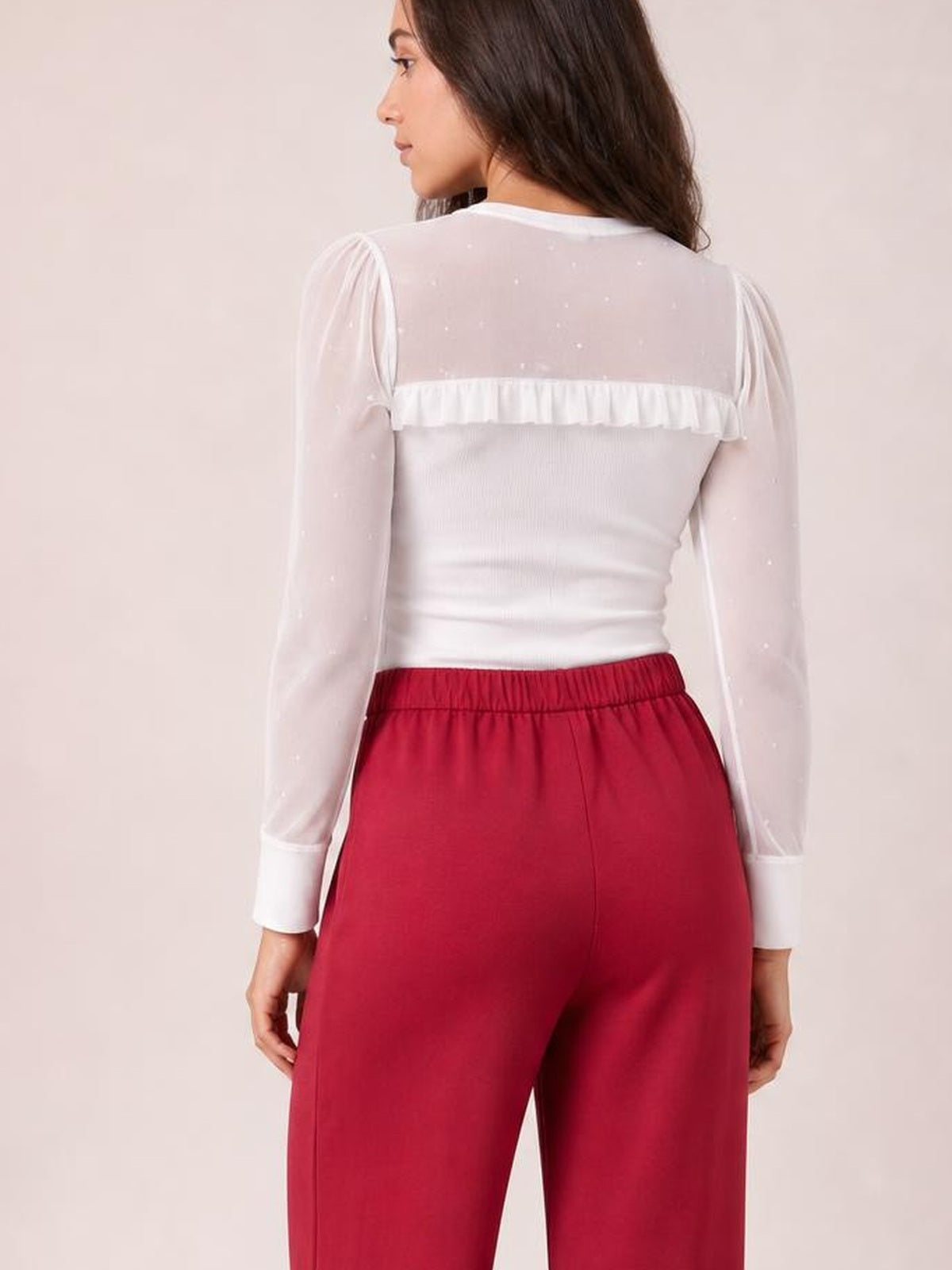 A model shown from behind wears high-waisted red wide-leg pants with a smooth silhouette, elastic waistband, and subtle center seam.