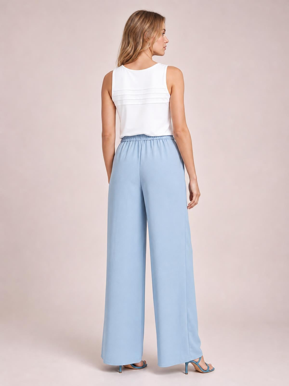 Model shown from the back and side wears pale blue high-waisted wide-leg pants with a relaxed, flowing silhouette and full-length hems.