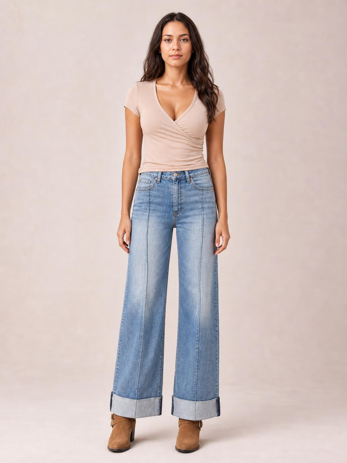 Front-facing model wears light blue high-waisted wide-leg cuffed jeans with contrast stitching, front pockets, and a structured denim silhouette.