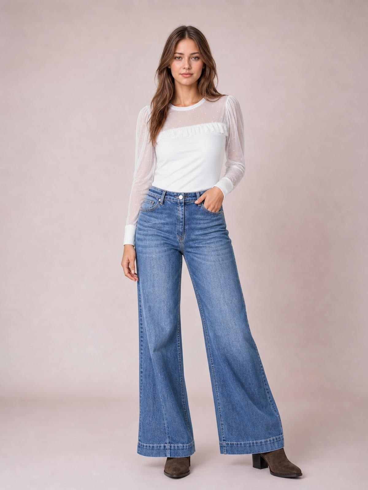 Model poses with one hand in the pocket of light-wash high-waisted wide leg jeans, featuring a relaxed silhouette, front fly, belt loops, and five-pocket construction.