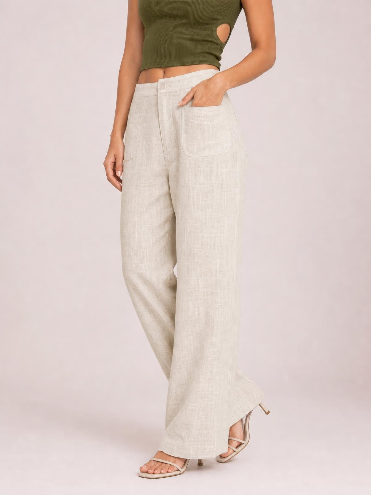 Model wears high-waisted wide-leg pants in a light natural shade, featuring a button closure, zipper fly, and large front pockets.