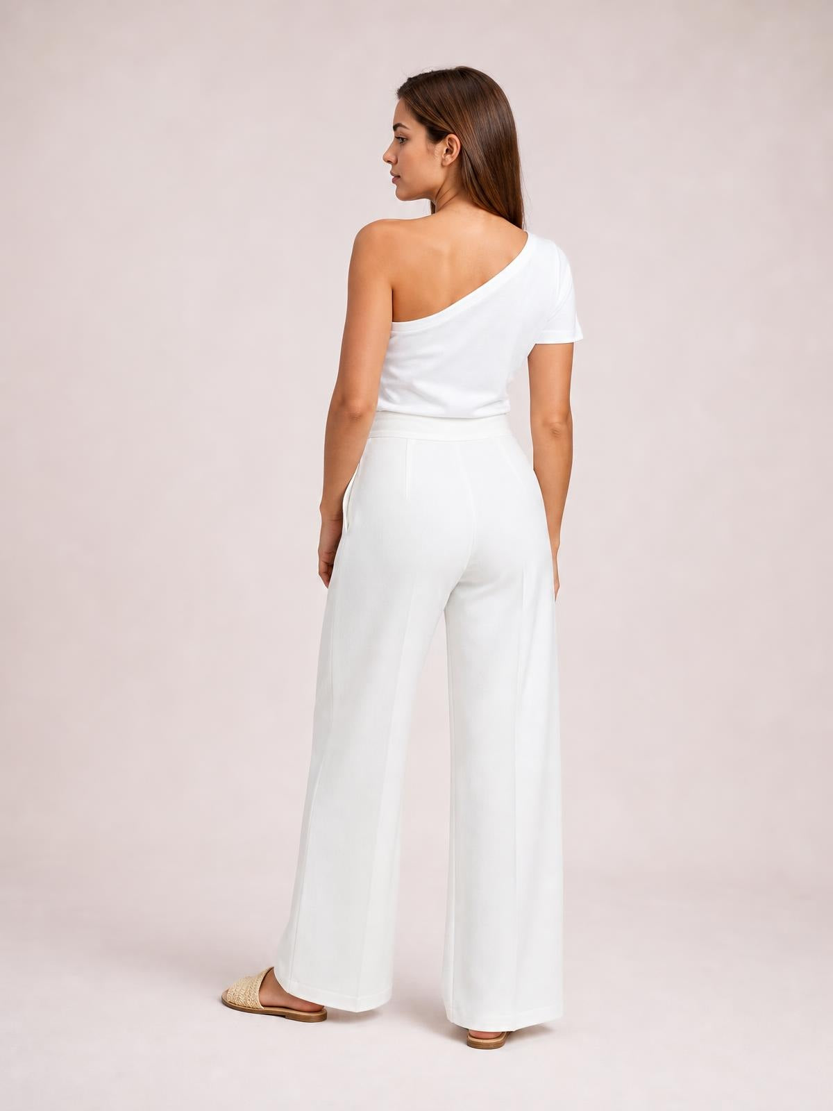 Model turned away wears white high-waisted wide-leg pants with a smooth waistband, relaxed silhouette, visible side pockets, and full-length hems.