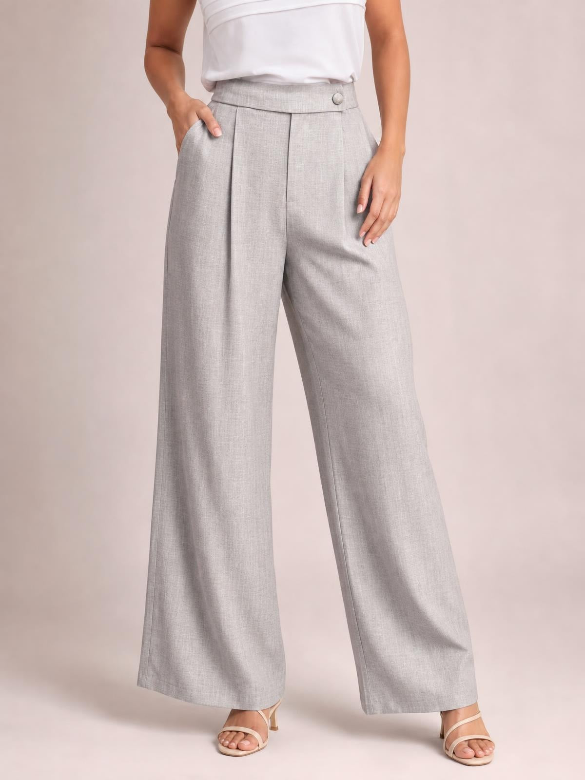 Model wearing light gray high-waisted wide-leg pleated pants with front pockets, a structured waistband, and full-length flowing legs.