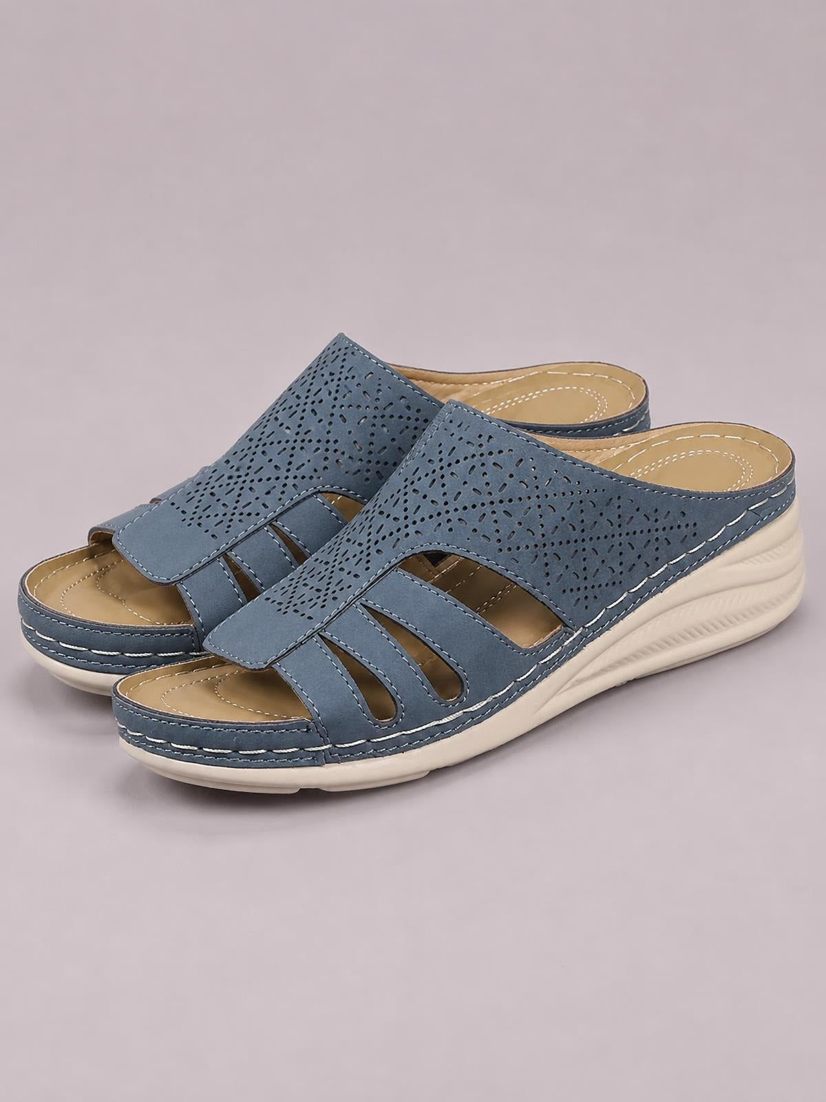 Blue PU leather hollow-out wedge sandals with perforated crossover straps, open toes, contrast stitching, and comfortable low wedge soles.