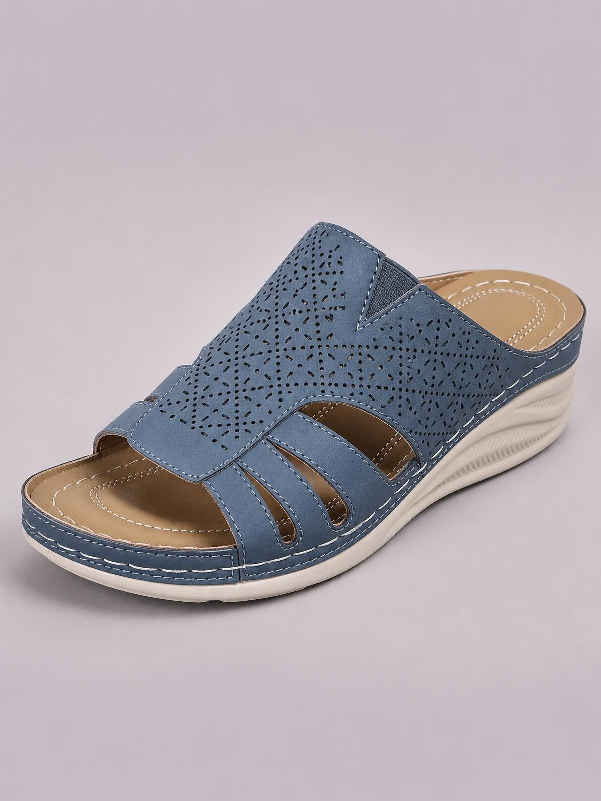Blue PU leather wedge sandals feature hollow-out perforations, layered open-toe straps, white contrast stitching, and a cushioned low wedge sole.