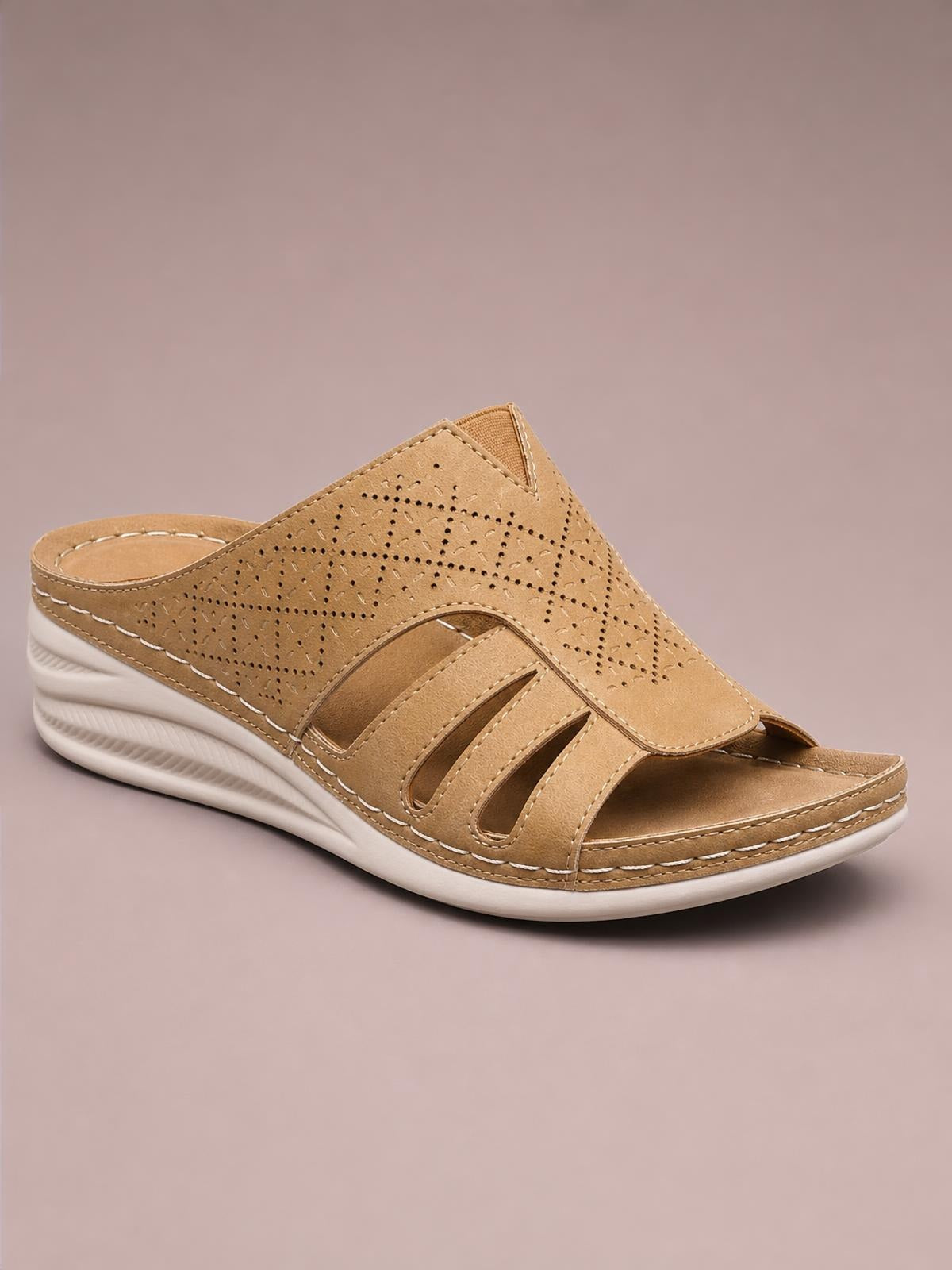 Tan hollow-out wedge sandals feature a perforated PU leather upper, open toe, cutout straps, contrast stitching, and a white rubber wedge sole.