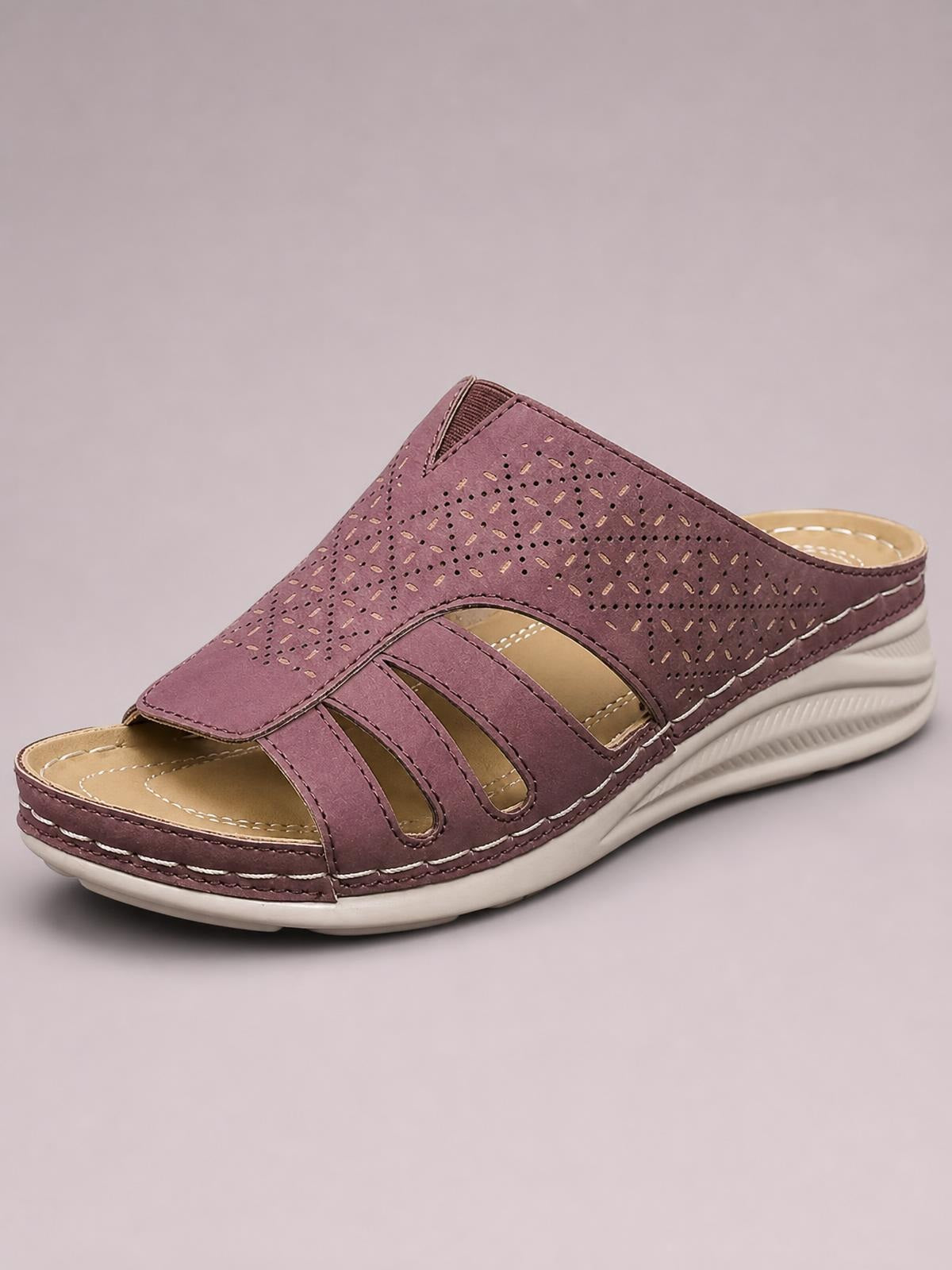 Mauve hollow-out wedge sandals feature an open toe, perforated upper, layered straps, stitched edges, and a low contoured rubber wedge sole.