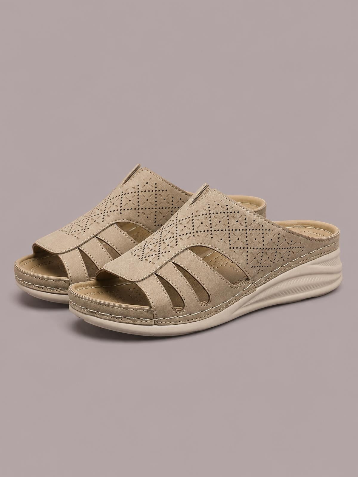 Tan hollow-out wedge sandals feature perforated PU leather uppers, open toes, slip-on styling, stitched details, and cushioned rubber platform soles.