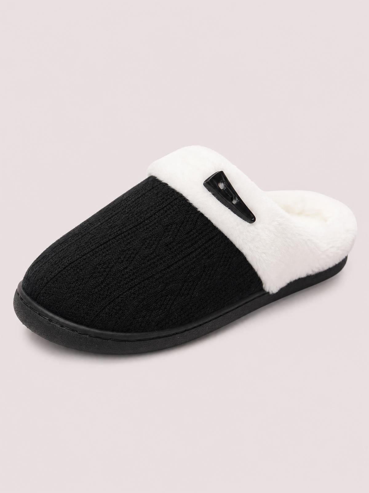 Black and white furry-texture flat slipper with a ribbed black toe, plush white upper, horn buckle detail, and sturdy rubber sole.