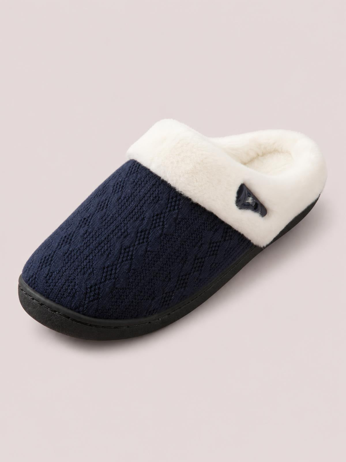 Navy textured flat slipper with a plush white furry lining, horn-style buckle detail, rounded closed toe, and sturdy black rubber sole.
