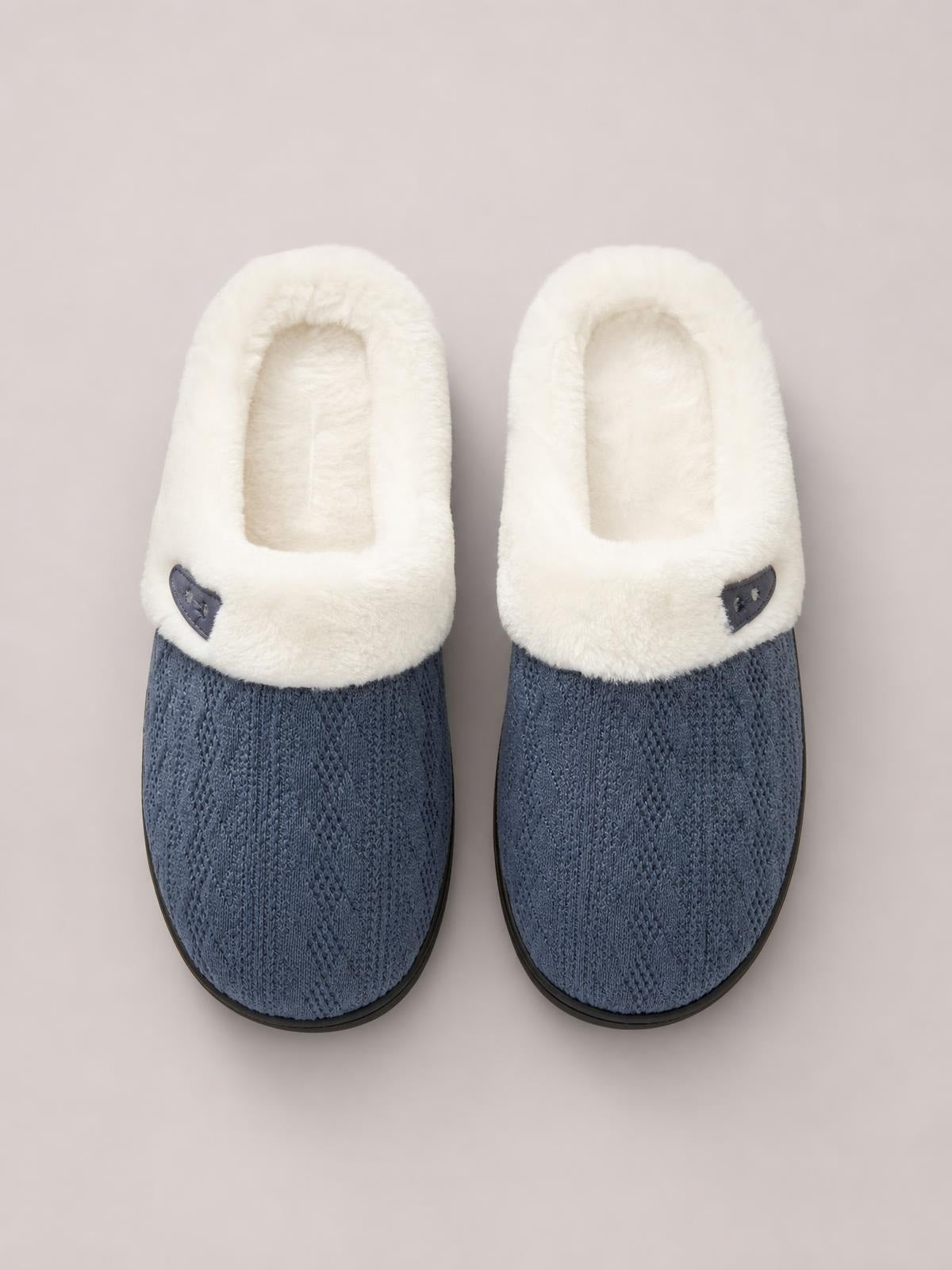 Blue flat slippers feature textured knit uppers, rounded toes, plush white furry lining, small horn buckles, and durable rubber soles.