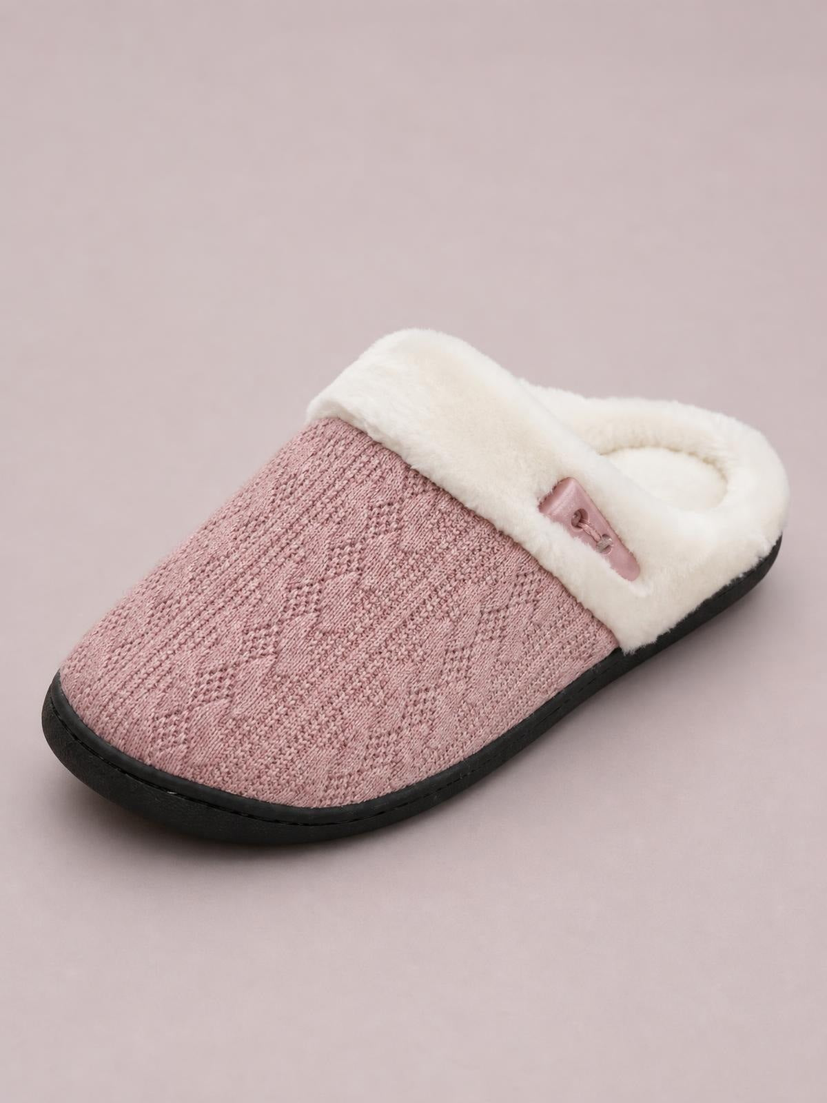 Pink flat slippers with a furry white lining, textured knit upper, horn buckle detail, open-back mule silhouette, and sturdy black rubber sole.