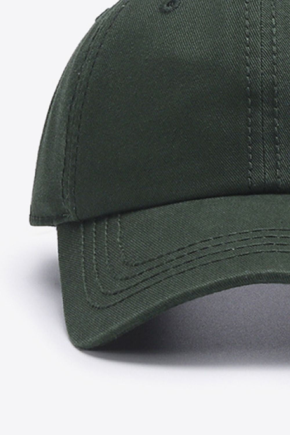 Solid dark green cotton baseball cap with a softly structured crown, curved brim, and neatly defined tonal stitching.