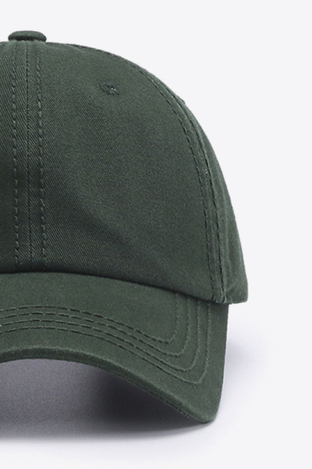 Solid dark green cotton baseball cap with a softly structured crown, curved brim, rounded top button, and neatly defined tonal stitching.
