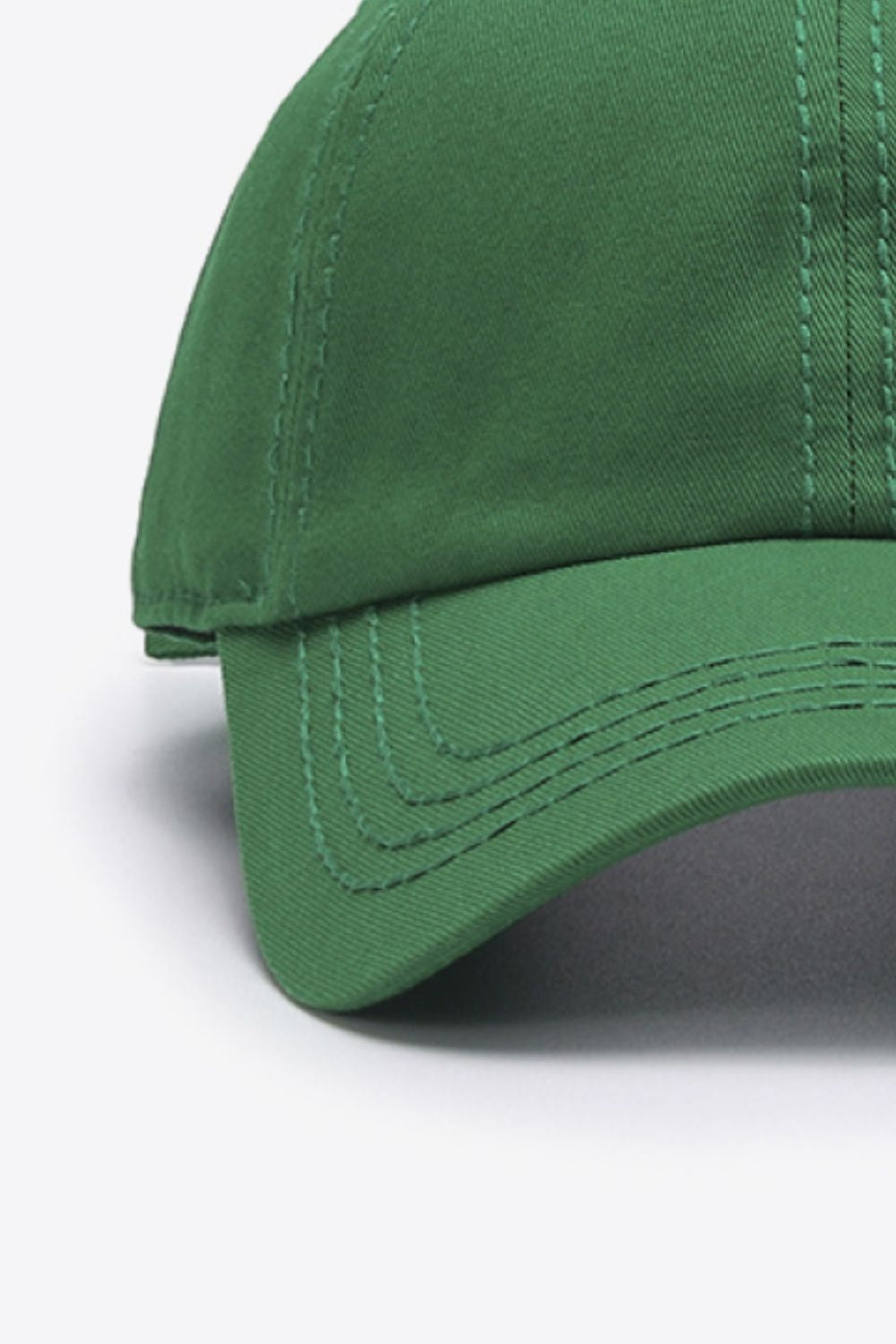 Solid green cotton baseball cap with a softly structured crown, curved brim, and neatly defined tonal stitching for a classic, polished silhouette.