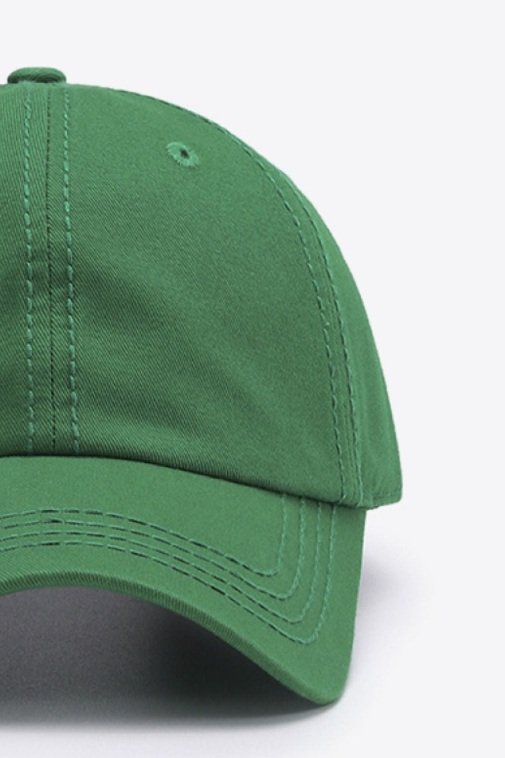 The In A Pretty World baseball cap is a solid green cotton style with a softly structured crown, curved brim, stitched panels, top button, and ventilation eyelet.