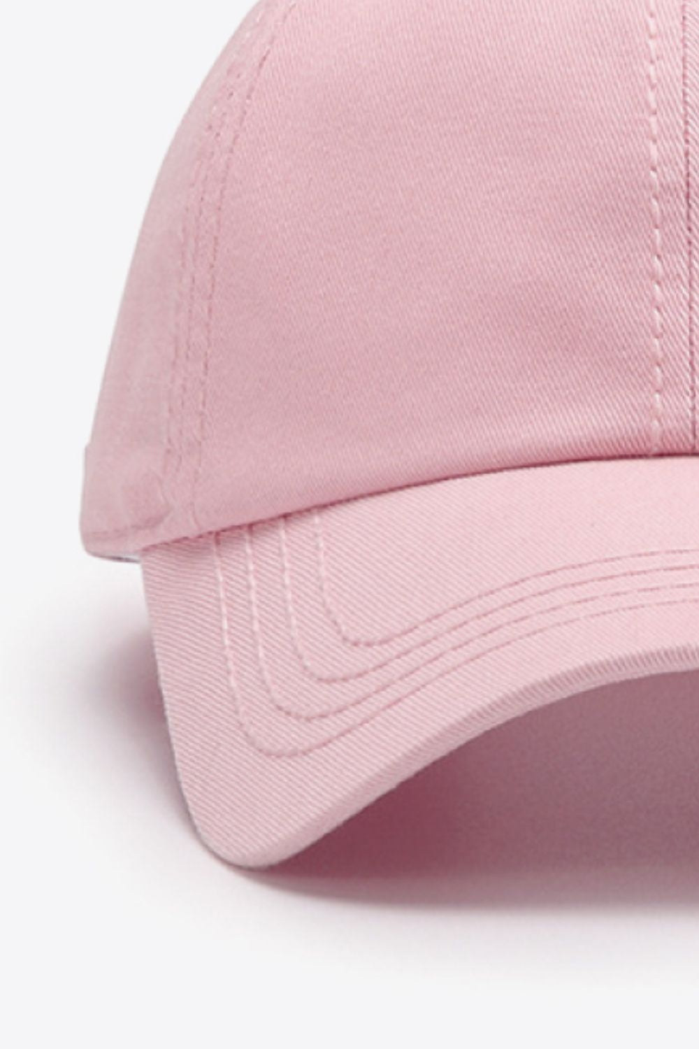 The In A Pretty World baseball cap is shown in solid pink cotton with a softly structured crown, curved brim, and neat tonal stitching.