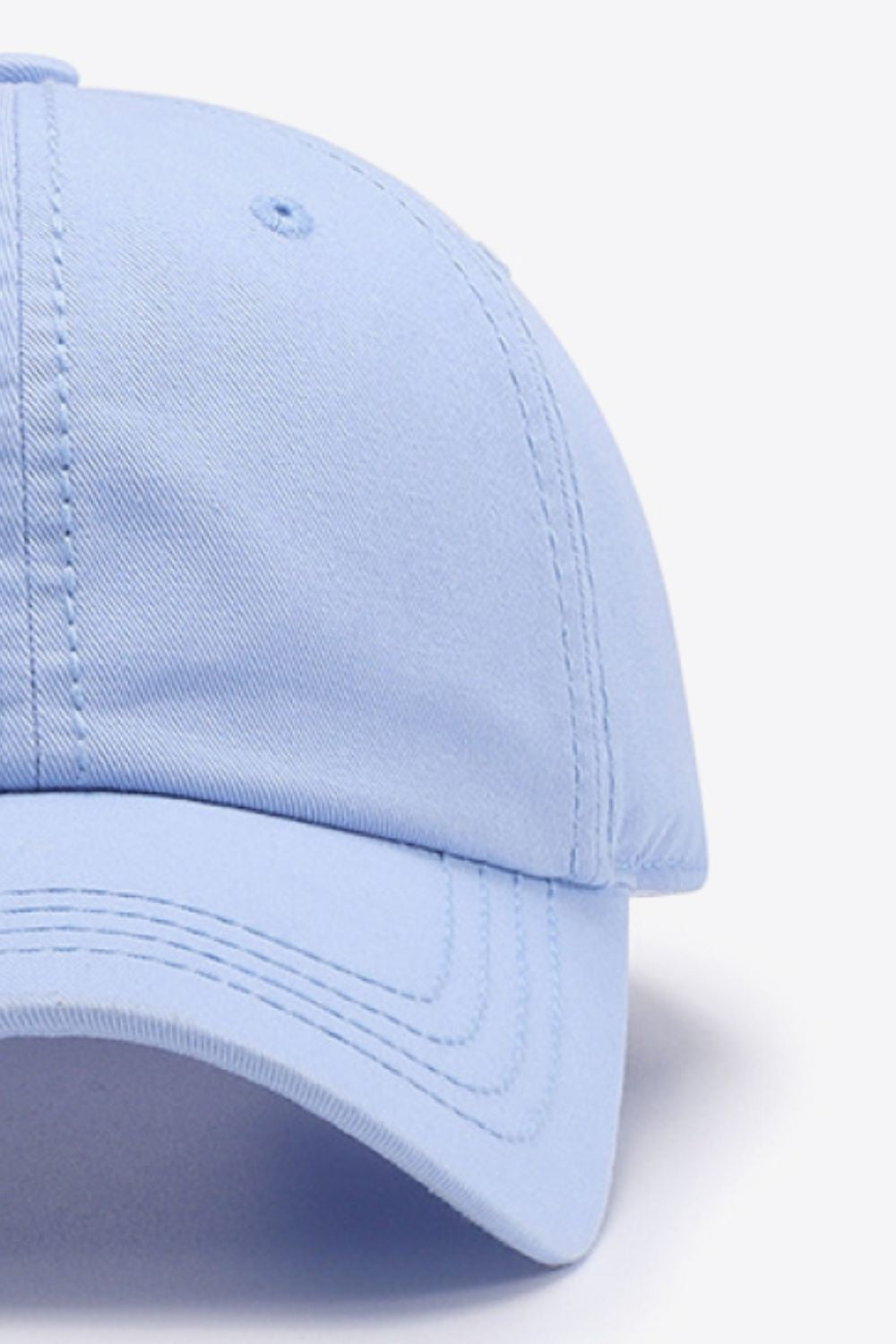 A light blue cotton baseball cap with a softly structured crown, curved brim, solid design, and neatly defined matching stitching.