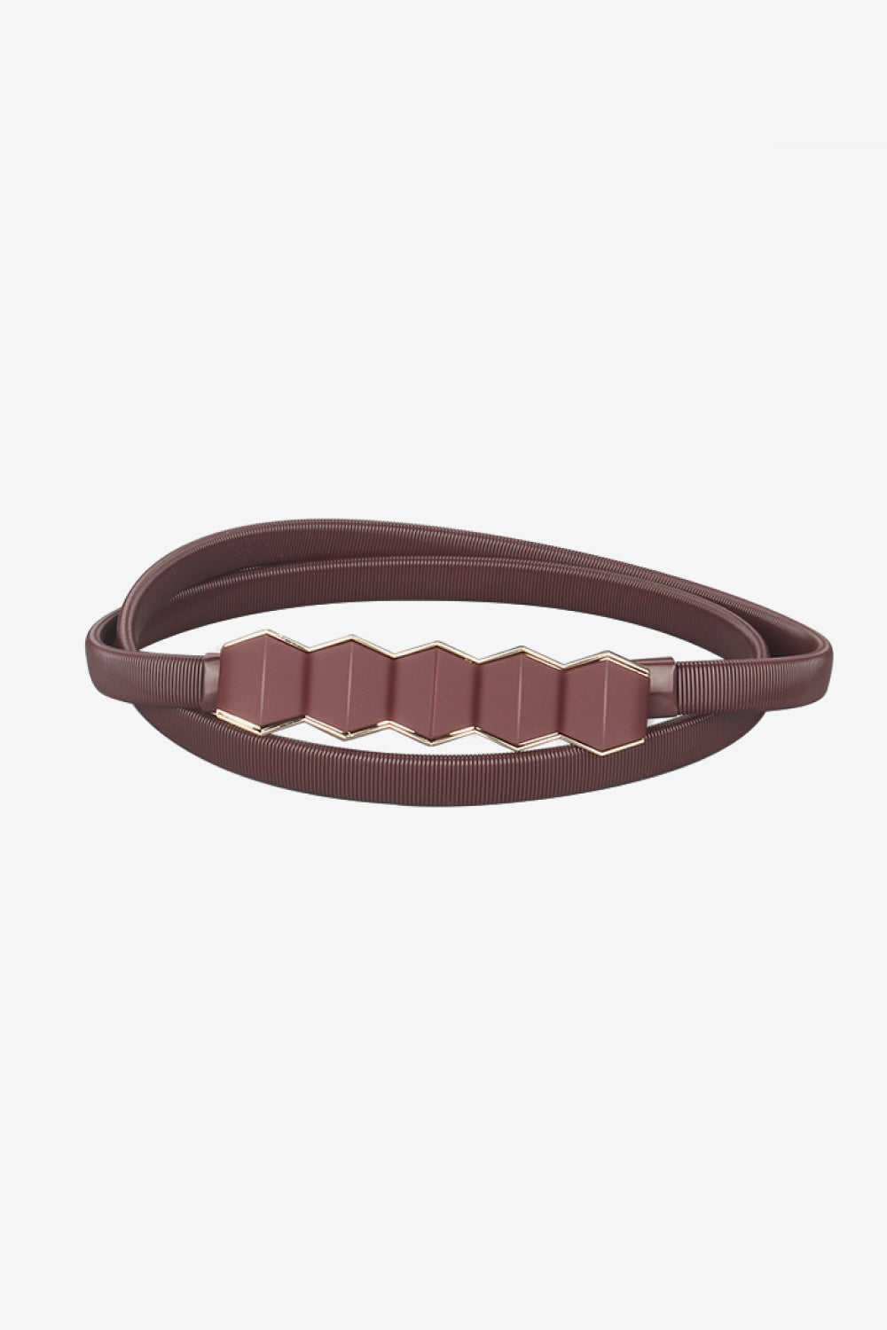Iron Skinny Belt in a deep brown tone with a narrow ribbed profile and distinctive geometric center detail, shown coiled to highlight its structured construction.