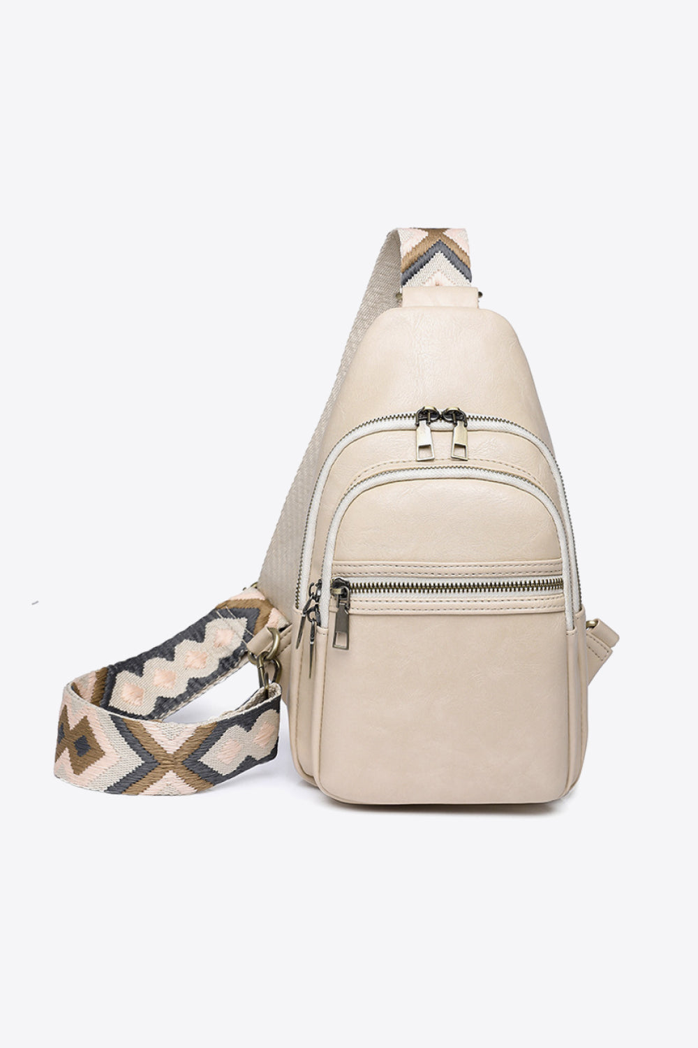 The It’s Your Time PU leather sling bag has a compact cream vertical silhouette, multiple front zip compartments, and a wide patterned strap.