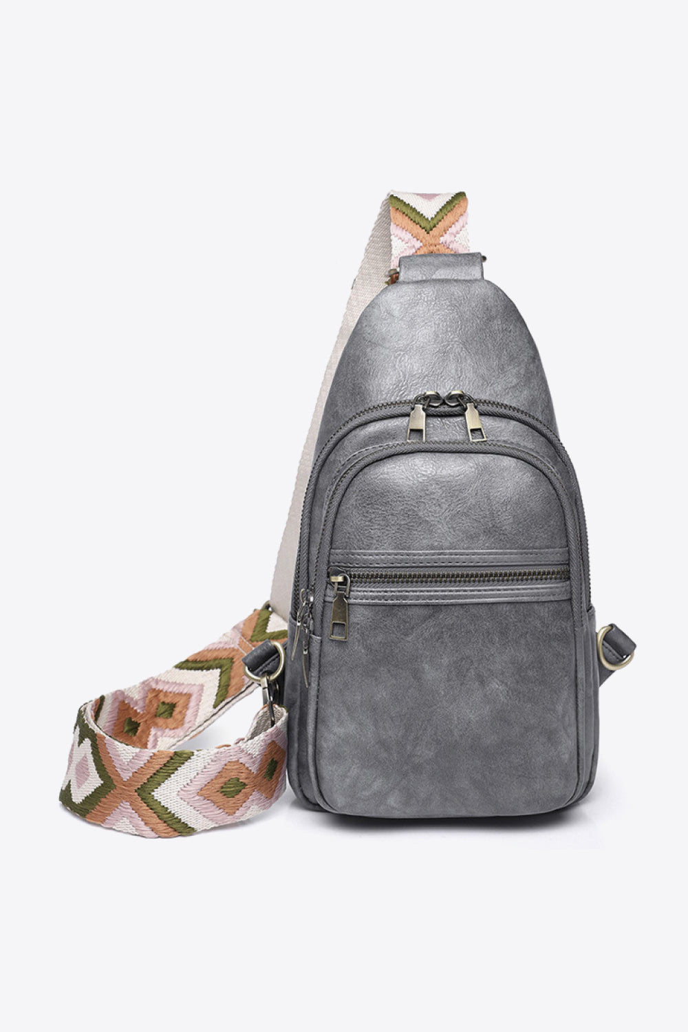 Gray PU leather sling bag with a compact vertical silhouette, layered front zip compartments, metal pulls, and a wide patterned crossbody strap.