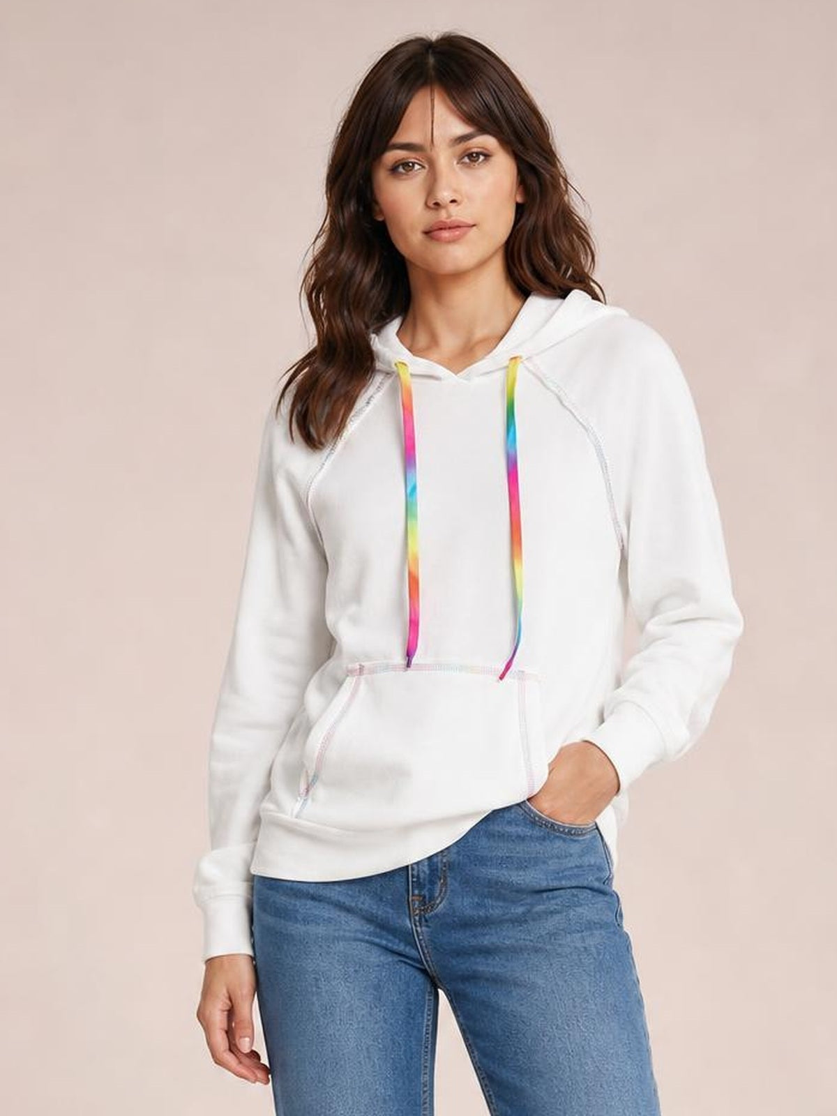 Model wearing a white raglan sleeve hoodie with contrast stitching, a drawstring hood with colorful cords, front pouch pocket, and relaxed silhouette.